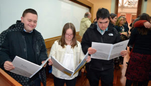 Algunos jóvenes con discapacidad hojean los materiales de catequesis.